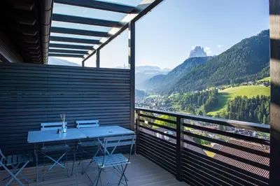 a balcony with a table and a view of a valley at Villa Mayr in Ortisei
