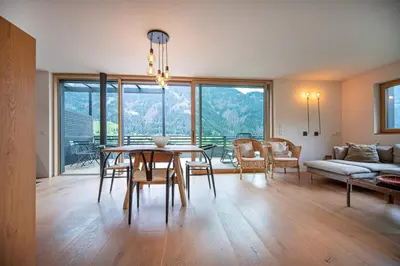 a living room with a table and chairs and a couch at Villa Mayr in Ortisei