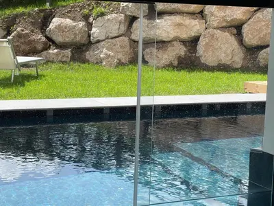 a swimming pool with a table and a chair next to it at Hotel Miravalle in Soraga