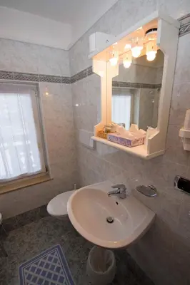 a bathroom with a sink and a mirror at Hotel Miravalle in Soraga