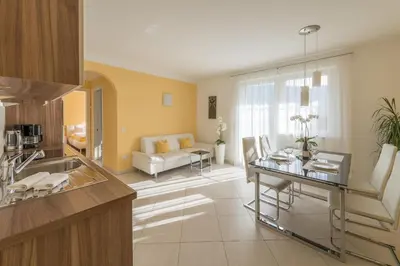 a kitchen and living room with a table and a couch at Quellenhof in Termeno