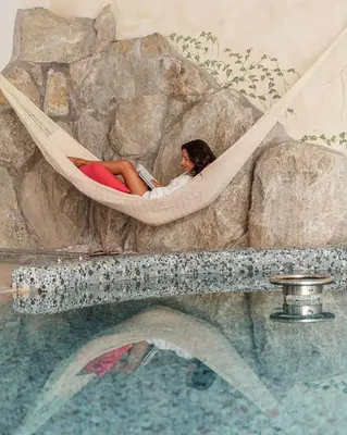 a woman laying in a hammock in a fake rock at DAS BADL - Smart Retreat AO in Caldaro