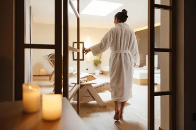 a woman standing in a room looking in a mirror at Hotel Melodia del Bosco in Badia