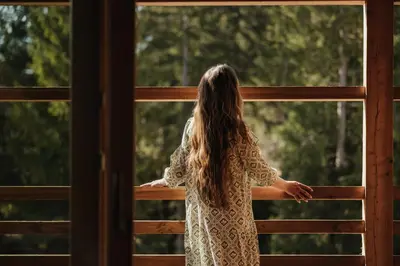 a young girl looking out of a window at Hotel Melodia del Bosco in Badia