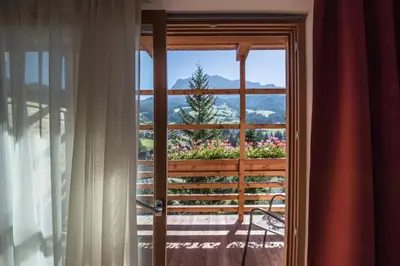 a view from the porch of a house with flowers at Hotel Melodia del Bosco in Badia