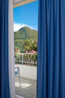 a view of a mountain from a window with a blue curtain at Seegarten in Caldaro