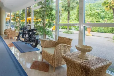a living room with a motorcycle in a room with windows at Seegarten in Caldaro