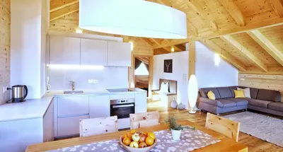 a kitchen and living room in a log cabin at Chalet Oberguggenberg in San Lorenzo di Sebato