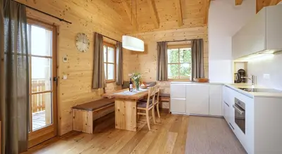 a kitchen with a table in a wooden house at Chalet Oberguggenberg in San Lorenzo di Sebato