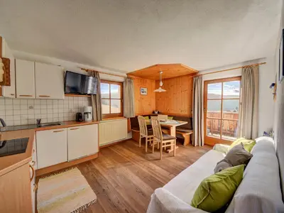 a living room with a couch and a kitchen at Tötscherhof in Terento