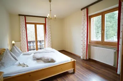 a bedroom with a bed and a window at Gstattlhof Mountain Farmhouse in Braies