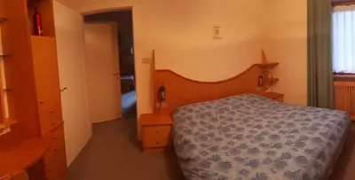 a bedroom with a bed with a blue comforter at Dreaming Ortisei in Ortisei