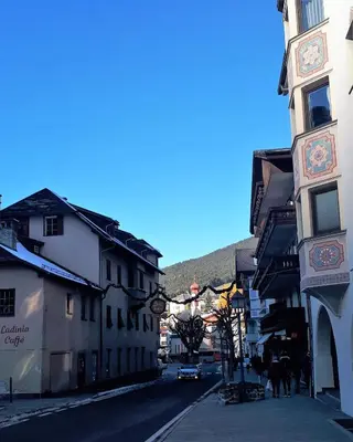 a city street with buildings and people walking down a street at Dreaming Ortisei in Ortisei