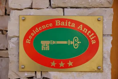 a sign on a brick wall that reads excellence batilla aminez at Residence Baita Antlia in Arabba