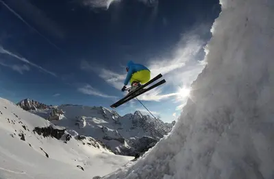 a person jumping in the air on skis in the snow at Residence Baita Antlia in Arabba