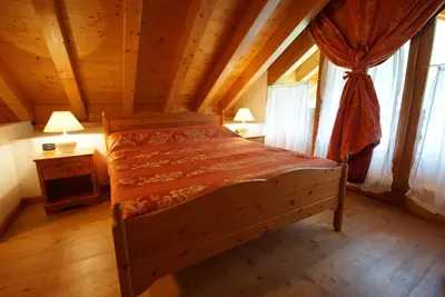 a bedroom with a bed in a wooden room at Residence Baita Antlia in Arabba