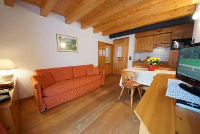 a living room with a couch and a desk with a computer at Residence Baita Antlia in Arabba