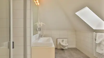 a white bathroom with a sink and a toilet at Hotel Sparerhof in Vilpiano