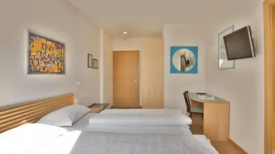 a bedroom with two beds and a tv on the wall at Hotel Sparerhof in Vilpiano