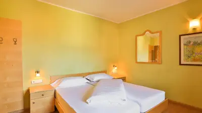 a bedroom with a white bed and a mirror at Hotel Sparerhof in Vilpiano