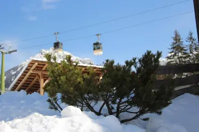 a ski lodge with a tree and a ski lift at Villa Ortensia in San Vigilio Di Marebbe