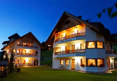 a large white building with lights on at night at Villa Ortensia in San Vigilio Di Marebbe