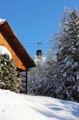 a ski lodge with a ski lift in the snow at Villa Ortensia in San Vigilio Di Marebbe