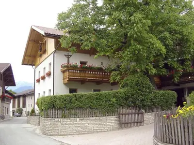 a building with a balcony and a tree in front of it at Kundlerhof in Stilves