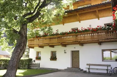 a building with a balcony with red flowers on it at Kundlerhof in Stilves