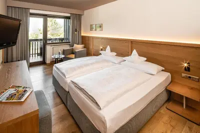 a living room with a couch and a large window at Royal Hotel Hinterhuber in Brunico