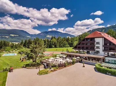 a bedroom with a large bed and a desk at Royal Hotel Hinterhuber in Brunico