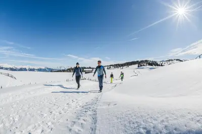 a man and woman walking a dog on a golf course at Royal Hotel Hinterhuber in Brunico