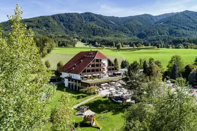 a window with a view of a pool and a house at Royal Hotel Hinterhuber in Brunico