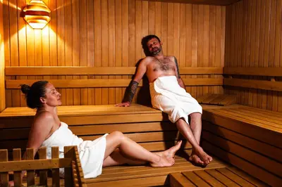 a man and woman sitting in a sauna at Hohe Gaisl in Braies