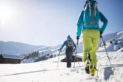 two people skiing down a snow covered slope at Hohe Gaisl in Braies