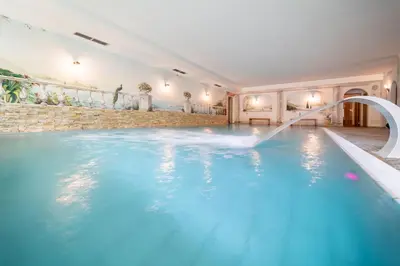 a swimming pool in a house with a water slide at Hohe Gaisl in Braies