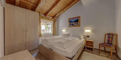 a bedroom with a bed and a window at Appartamento Luna in Campitello di Fassa