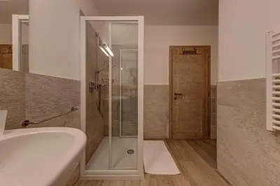 a bathroom with a shower and a tub and a sink at Appartamento Luna in Campitello di Fassa