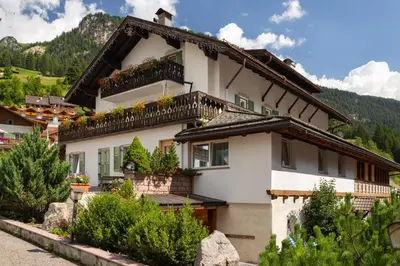 a house in the mountains with flowers on the balconies at Appartamento Luna in Campitello di Fassa
