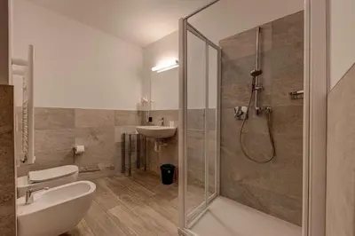 a bathroom with a shower and a toilet and a sink at Appartamento Luna in Campitello di Fassa