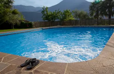 a swimming pool with a pair of sandals in it at Pension Sonnheim in Gargazzone