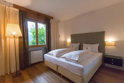 a bedroom with a large bed and a large window at Pension Sonnheim in Gargazzone