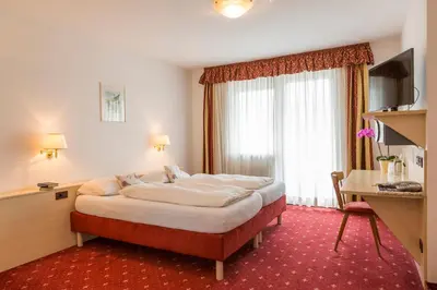 a hotel room with a large bed and a desk at Hotel Markushof - Adults only in Ora/Auer