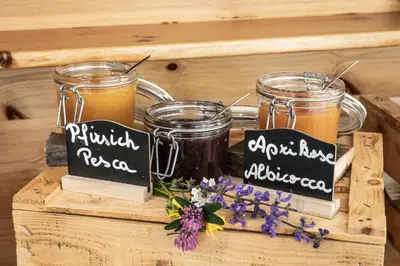 two jars of honey and flowers on a wooden crate at Hotel Langeshof in Anterivo