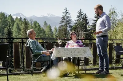two men and a woman sitting at a table at Hotel Langeshof in Anterivo