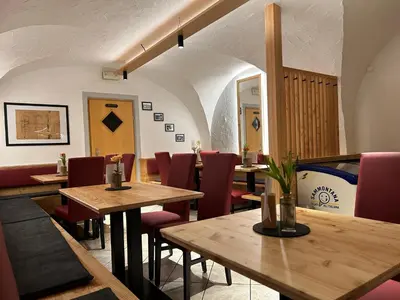 a restaurant with wooden tables and red chairs at Hotel Langeshof in Anterivo