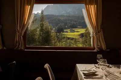 a dining room with a table and a window at Dolomiti Lodge Alverà in Cortina dʼAmpezzo