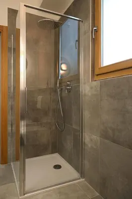 a shower with a glass door in a bathroom at Residence Rösch in Merano