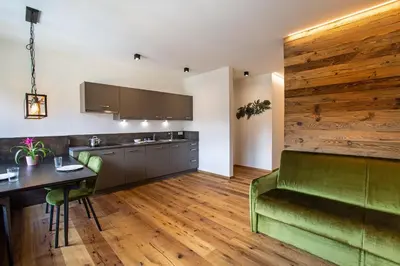 a kitchen with a green couch and a table at Residence Rösch in Merano