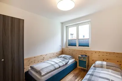 a bedroom with two beds and a window at Residence Rösch in Merano